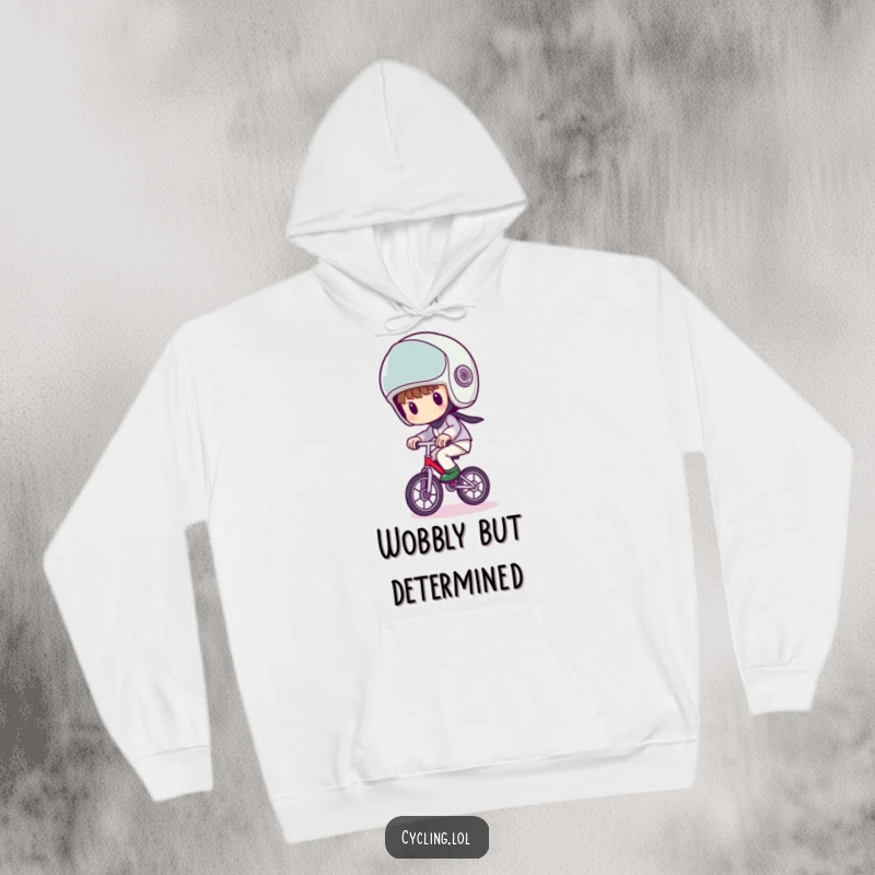 Funny hoodie of a character wearing a comically large helmet, wobbling precariously on a unicycle, offering warmth and humor.